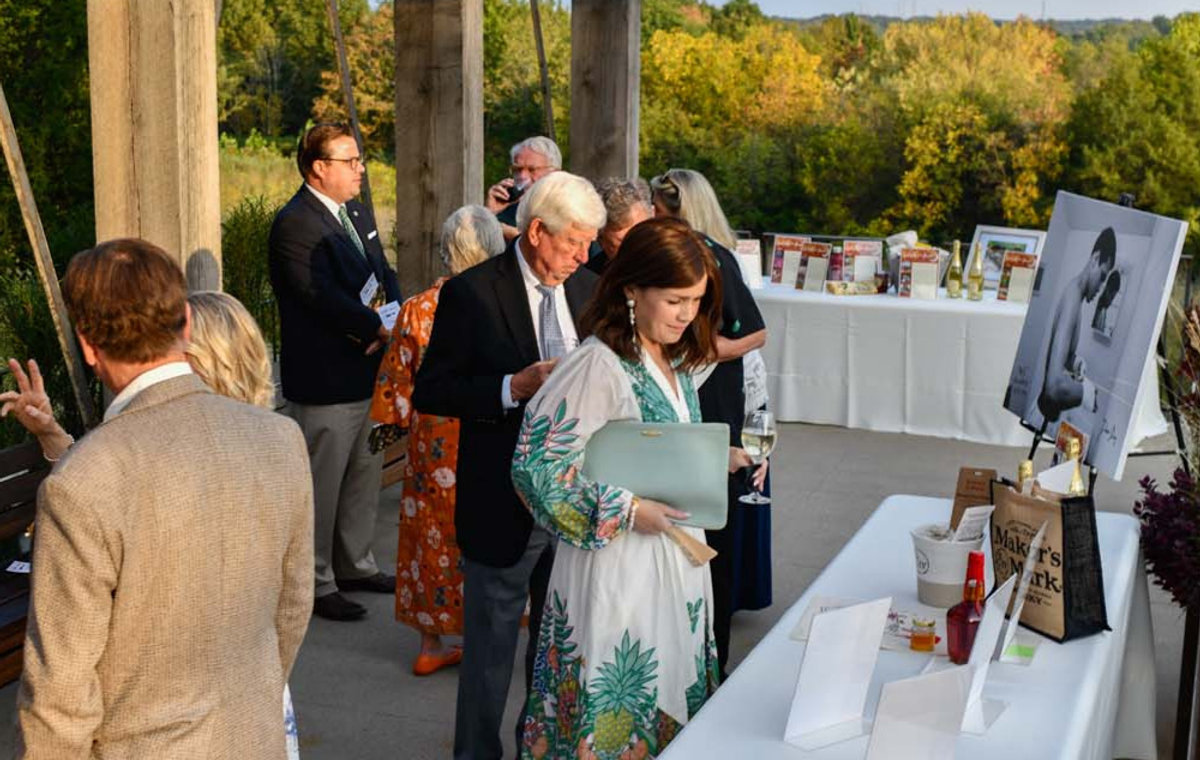 Guests at an outdoor evening benefit at Locust Grove